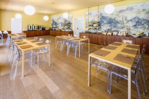 a room with tables and chairs in a restaurant at Hotel Auronzo Dolomites, Affiliated by Melia in Auronzo di Cadore