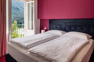 a bedroom with a large bed with a large window at Hotel Auronzo Dolomites, Affiliated by Melia in Auronzo di Cadore +25 photos