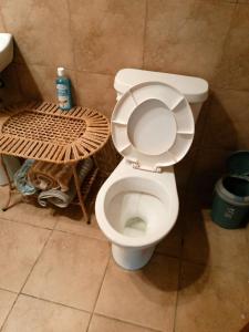a bathroom with a toilet with the lid up at Casa del Río, Vilcabamba in Loja