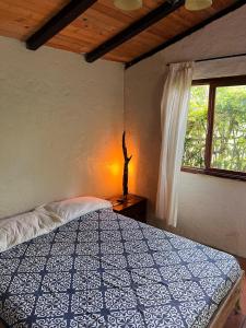 a bedroom with a bed and a window at Casa del Río, Vilcabamba in Loja
