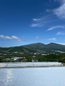a large body of water with mountains in the background at Guest house AZSINN in Ueda