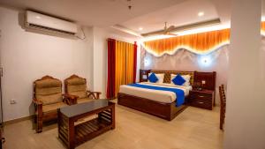 a bedroom with a bed and a desk and chair at Harshavardhana Inn in Kizhake Chālakudi +42 photos