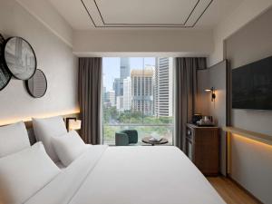 a hotel room with a large bed and a window at All Seasons Jakarta Thamrin in Jakarta +72 photos