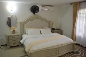 a bedroom with a large bed and a mirror at Masaki Comfort III Dar es Salaam Tanzania in Dar es Salaam