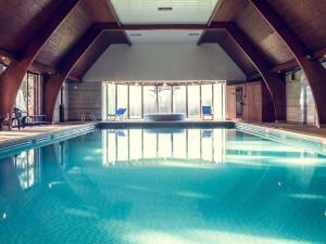 a swimming pool with blue water in a building at Mercure Hull Grange Park Hotel in Hull