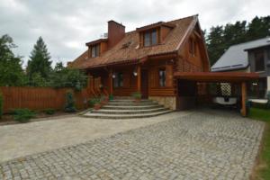 a house with a stone driveway in front of it at Mazury Drewniany Dom Malkinie k/Ełku in Małkinie