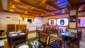 a restaurant with tables and chairs in a room at Harshavardhana Inn in Kizhake Chālakudi
