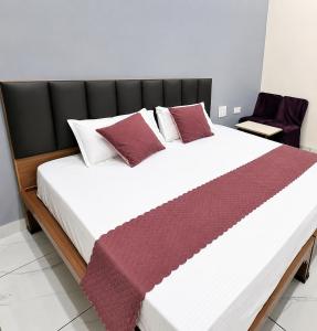 a bedroom with a large bed with red and white pillows at Hotel Balram Palace Khatu Shyam in Rīngas