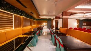 a dining room with tables and red chairs at Harshavardhana Inn in Kizhake Chālakudi