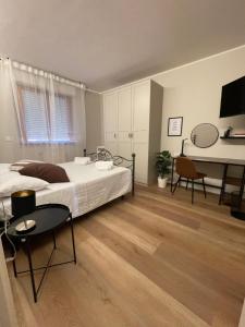a bedroom with a bed and a table and a desk at Guest House 36 private parking in Orbetello