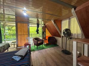 a room with a bed and a desk and chairs at Yaxlik River Lodge in Lanquín