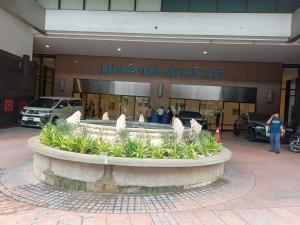 a building with a fountain in front of a car dealership at Home Time Square Residence in Kuala Lumpur