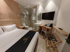 a hotel room with a bed and a desk and a bathroom at V Boutique Hotel Seremban in Seremban +18 photos