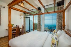 a bedroom with a bed and a view of the ocean at Leisure Mount Villa in Haputale