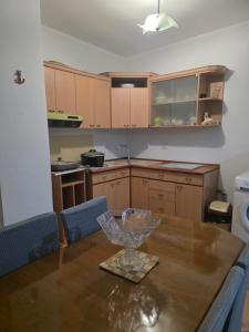 a kitchen with a wooden table with a glass bowl on it at APP Apartament in Durrës
