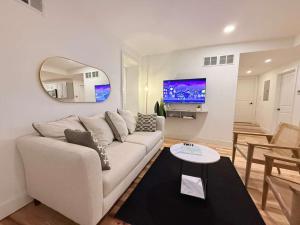 a living room with a white couch and a tv at Charming 1-Bed Apt WiFi, Fully Equipped Kitchen in Rochester