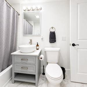 a white bathroom with a sink and a toilet at Charming 1-Bed Apt WiFi, Fully Equipped Kitchen in Rochester