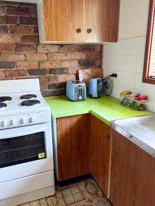 a kitchen with a white stove and a microwave at Speers Point Serviced Apartments in Cockle Creek