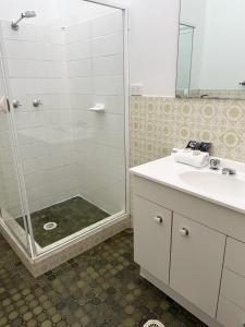 a bathroom with a shower and a sink at Speers Point Serviced Apartments in Cockle Creek