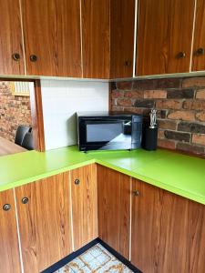 a microwave on a green counter in a kitchen at Speers Point Serviced Apartments in Cockle Creek