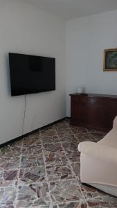 a living room with a flat screen tv and a couch at La Terrazza sul Trebbia in Ottone +2 photos