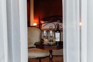 a table with two wine glasses and a bottle of wine at KISLOV Vineyard Boutique Hotel in Hagimus +23 photos