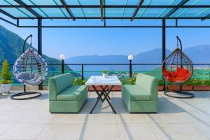 a patio with chairs and a table with a view at Doon Nature Valley Resort, Mussoorie in Mussoorie
