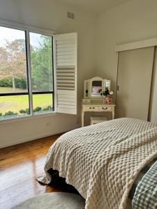 a bedroom with a bed and a table with a microwave at The Thirlmere Homestead in Thirlmere