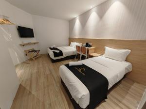 a hotel room with two beds and a television at V Boutique Hotel Seremban in Seremban