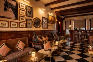 a bar with a couch and tables and a checkered floor at Raj Kuber - A Boutique Lake View Hotel in Udaipur