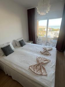 a bedroom with a white bed with towels on it at Apartman Raba in Šušanj