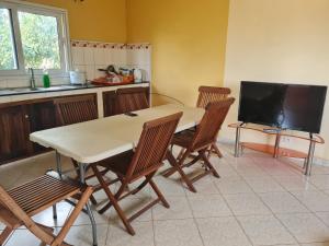 a kitchen with a table and chairs and a television at BazarBe Appartment in Nosy Be