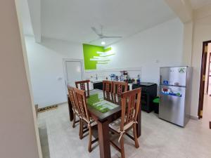 a kitchen with a table with chairs and a refrigerator at BazarBe Appartment in Nosy Be