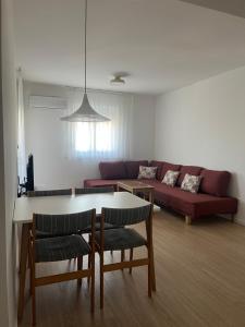 a living room with a couch and a table and chairs at Apartman Raba in Šušanj