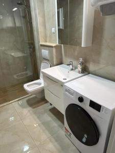 a bathroom with a sink and a washing machine at Apartman Raba in Šušanj +12 photos
