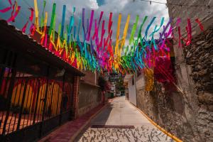 a alley with colorful streamers hanging from a building at Hostal Doña Emma in Pahuatlán del Valle