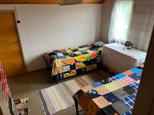 a room with two twin beds and a window at Vanha maatilanpihapiiri Patula in Pertunmaa