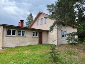 a house with a red chimney on top of it at Vanha maatilanpihapiiri Patula in Pertunmaa