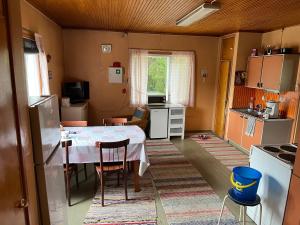 a kitchen with a table and chairs in a room at Vanha maatilanpihapiiri Patula in Pertunmaa