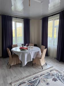 a dining room with a white table and chairs at Kolsay Amanat Resort in Kurmenty