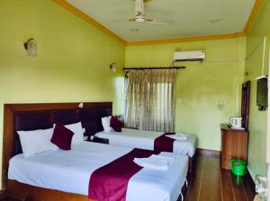 two beds in a room with green walls at Hotel Buddha Palace in Rummindei +3 photos