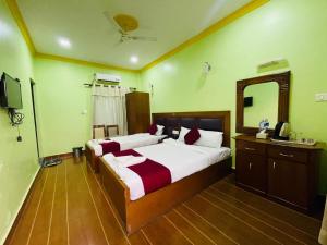 a hotel room with two beds and a mirror at Hotel Buddha Palace in Rummindei