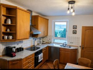 eine Küche mit Holzschränken, Spüle und Fenster in der Unterkunft SollingNest in Uslar + 7 Fotos
