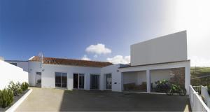 ein weißes Haus mit vielen Fenstern in der Unterkunft Cantinho da Ilha in Achadinha