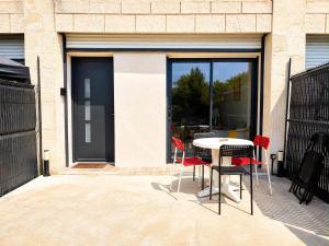 a patio with a table and chairs and a window at Maison moderne 3 chambres avec terrasse Maison Familiale Région Bordeaux in Salleboeuf