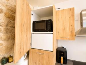 a microwave oven sitting inside of a cabinet in a kitchen at Maison moderne 3 chambres avec terrasse Maison Familiale Région Bordeaux in Salleboeuf +6 photos