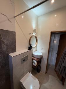 a bathroom with a toilet and a sink and a mirror at KameronStudio in Yaoundé