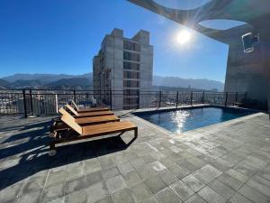 a patio with a bench and a pool on a building at depa en el centro con estacionamiento in Monterrey