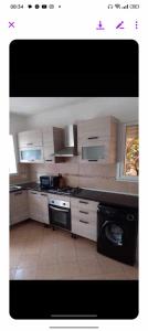 a kitchen with white cabinets and a stove top oven at Ridha in Djerba