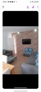 a living room with a couch and a brick wall at Ridha in Djerba